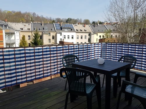kleiner Tisch mit drei Stühlen auf dem Balkon