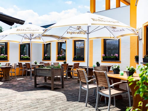 Außenterrasse mit Gartenmöbeln und Sonnenschirmen
