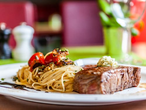 Teller mit einem Stück Fleisch und Pasta