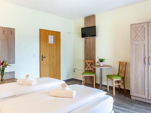 Standard Doppelzimmer mit TV und einem Tisch und zwei Stühlen
