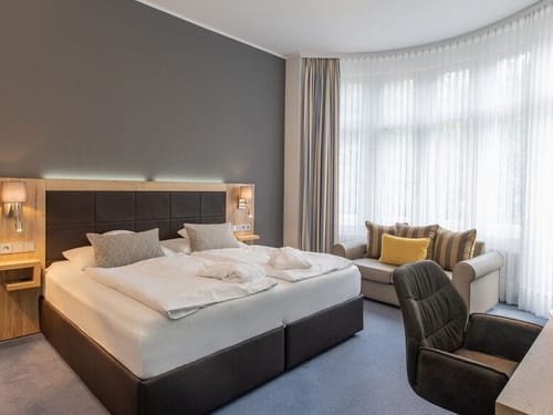 Zimmer mit Couch, Schreibtisch, Stuhl und TV