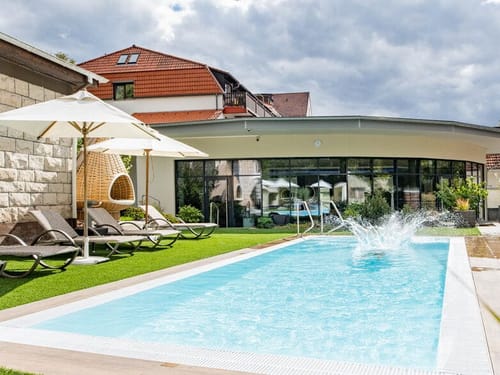 Outdoor Pool mit Liegen und Sonnenschirmen