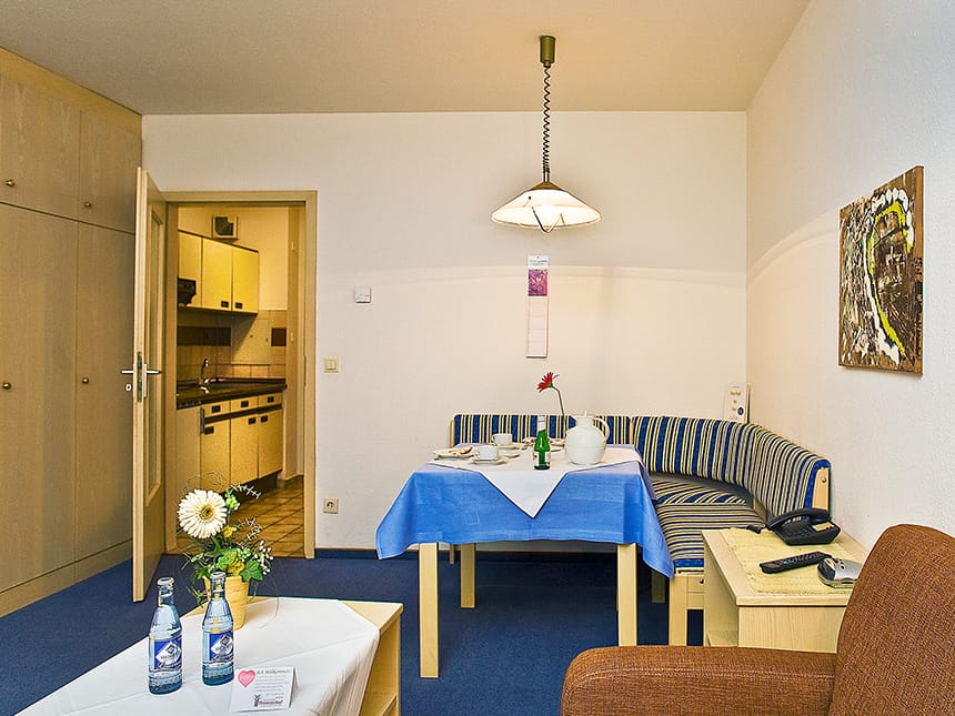 Zimmer mit Sitzecke, Sessel und zwei Tischen