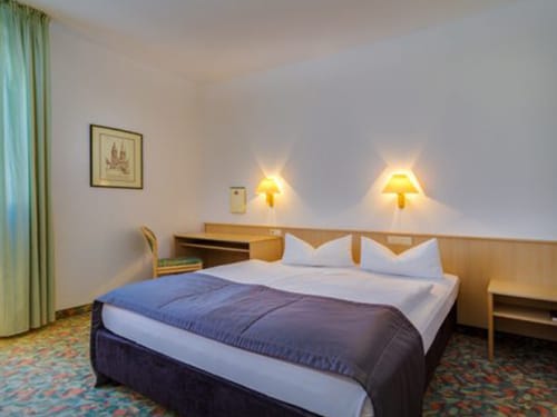 Schlichtes Hotelzimmer mit Doppelbett und Schreibtisch