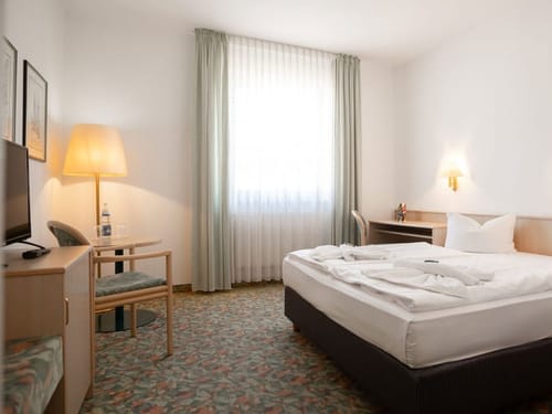 Helles und komfortables Doppelzimmer mit Doppelbett, Sitzecke und großzügigem Fenster
