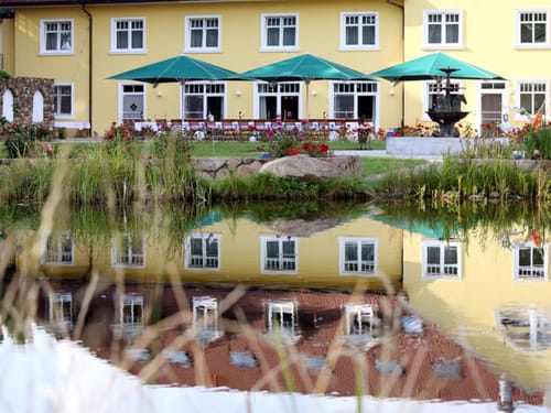 Hausansicht mit Hotelgarten und Terrasse