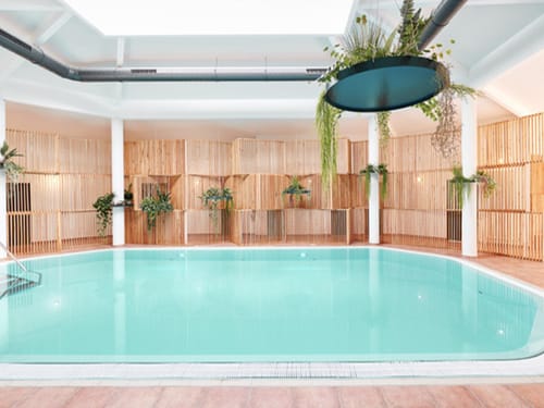 Indoor-Pool mit Sichtschutz und grüner Bepflanzung