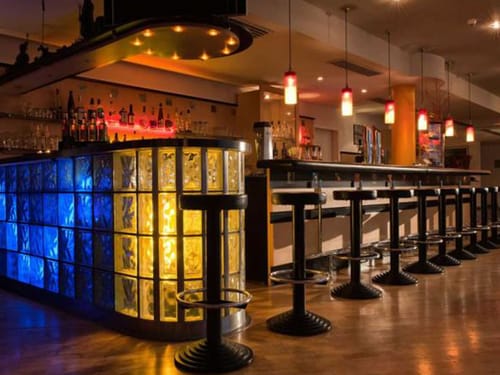 Hotel Bar mit farbiger Beleuchtung und Barhockern