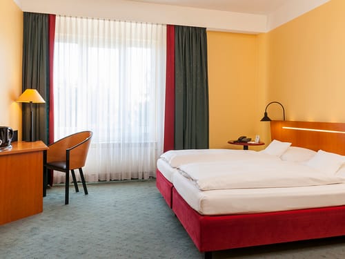 Standard Doppelzimmer mit Doppelbett, Sessel, Schreibtisch und Kaffee und Teezubereiter