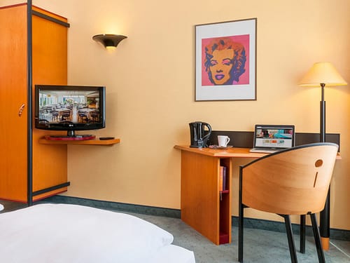 Wohnbereich Standard Doppelzimmer mit Sessel, Schreibtisch, TV und Kleiderschrank