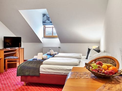 Superior Dachzimmer mit Boxspringbettm Schreibtisch, Stuhl und TV