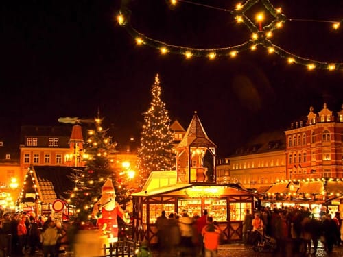 beleuchtete Häuser und Bäume sowie Weihnachtsstände