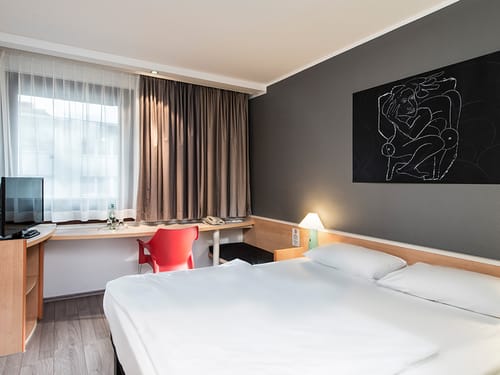 Standard Double Room mit Doppelbett, Schreibtisch, Stuhl und TV