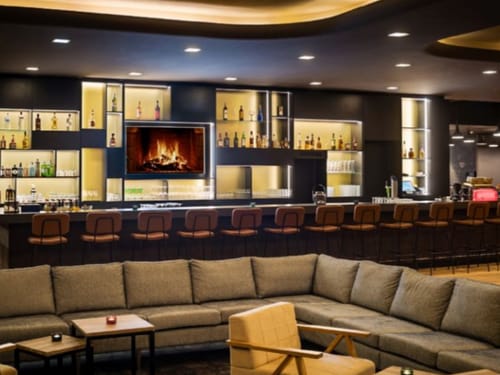 Loungebereich mit Bar, Barhockern, großzügiger Couch und Sesseln