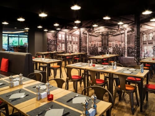 Restaurant mit verschieden Tischguppen und Wandgemälden