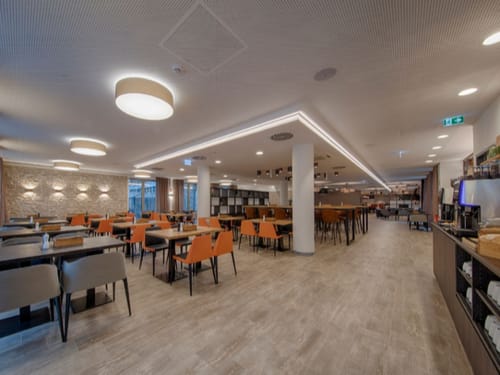 Heller Frühstücksraum mit vielen Tischgruppen