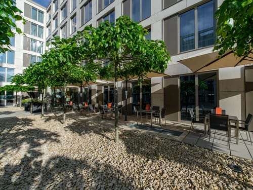 Große Terrasse mit Tischen, Stühlen und Sonnenschirmen