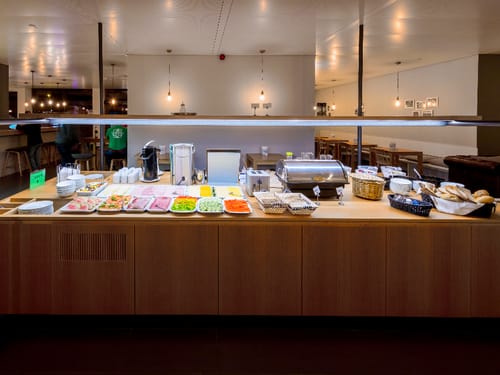 Frühstücksbuffet mit verschiedenen Speisen, Müsli und Obst