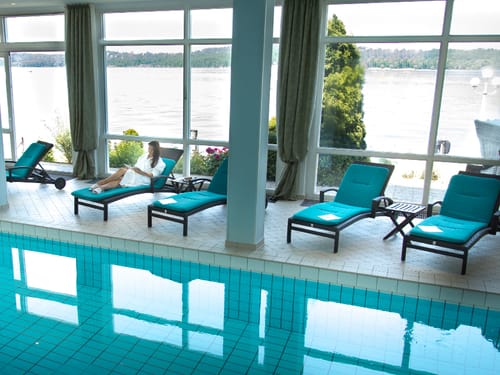 Pool mit Relaxliegen und Panoramafenstern