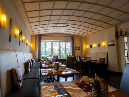 Cafe&Bistro mit verschiedenen Sitzmöglichkeiten und eingedeckten Tischen