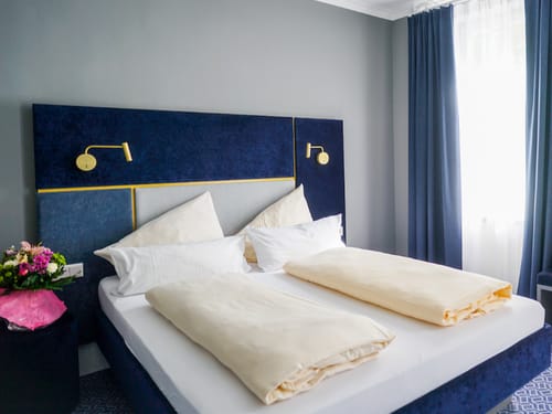 Doppelzimmer für Zwei mit Doppelbett und Leselampen am Bett