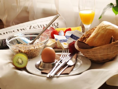 Frühstücksauswahl mit verschiedenen Speisen, Brötchen, Müsli und Saft