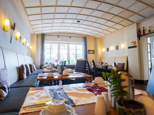 Speisesaal am Morgen mit eingedeckten Tischgruppen