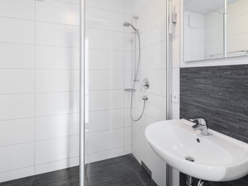 Bad mit Dusche, Spiegel und Waschbecken