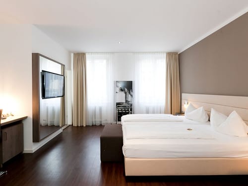 modernes Doppelzimmer mit Doppelbett, TV, Spiegel und Sideboard