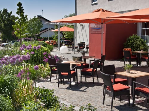 Aussenterrasse mit Stühlen und Sonnenschirmen