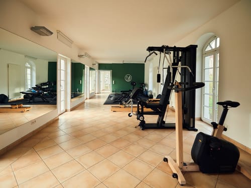 Entdecken Sie unseren modernen Fitnessraum mit erstklassiger Ausstattung. Perfekt für effektives Kraft- und Ausdauertraining. Ein großer Spiegel sorgt für optimale Trainingserfahrung.