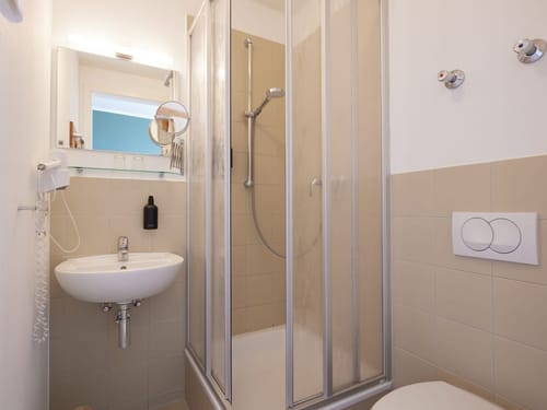 Modernes kleines Badezimmer mit Dusche, Waschbecken und WC.