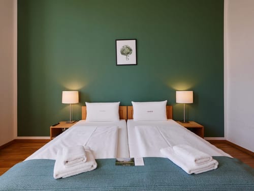 Modernes, gemütliches Hotelzimmer mit Doppelbett und grüner Akzentwand