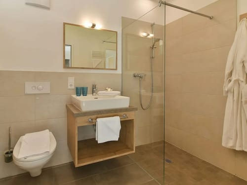 Badbereich mit Spiegel, Waschtisch und Dusche