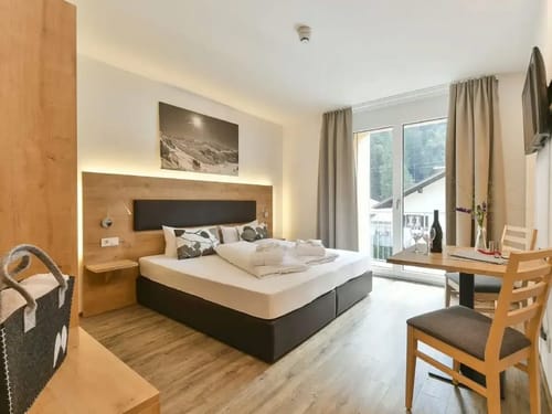 Zweibettzimmer mit Doppelbett, Tisch, zwei Stühlen und Balkon
