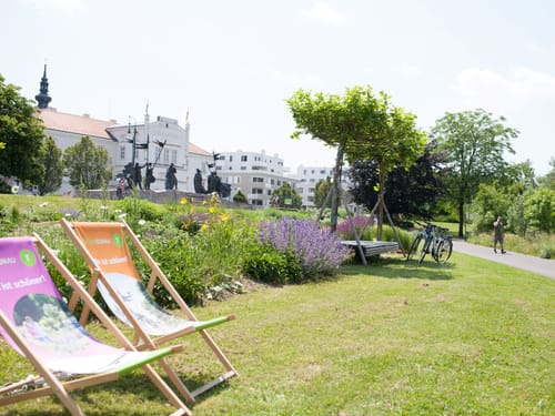 Hotelgarten mit Wiesenfläche und Liegestühlen
