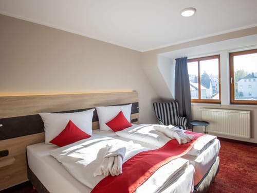 Modernes Hotelzimmer mit gemütlichem Doppelbett und Blick aus dem Fenster.