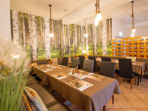 Gemütliches Restaurant mit Waldtapete und moderner Einrichtung