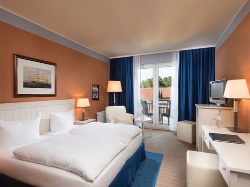 Doppelzimmer Classic mit Doppelbett, Sessel, Steh und Leselampe, Schreibtisch und TV
