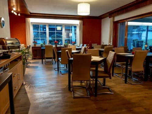 Restaurant mit verschiedenen Tischgruppen und Zugang zur Terrasse