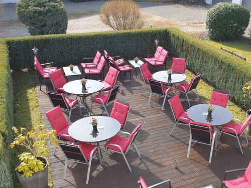 verschieden Tischgruppen auf der Terrasse mit pinken Polstern