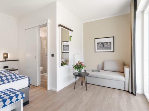Doppelzimmer mit Loungebereoch wie Sessel und kleinem Tisch