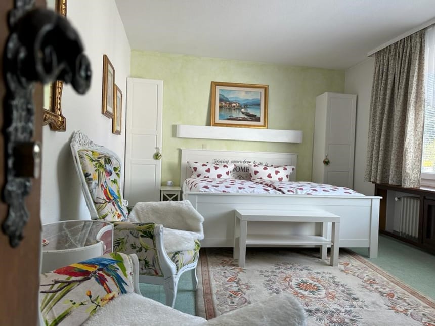 Standard Zimmer mit Doppelbett, Kleiderschränke, Sessel und Tisch