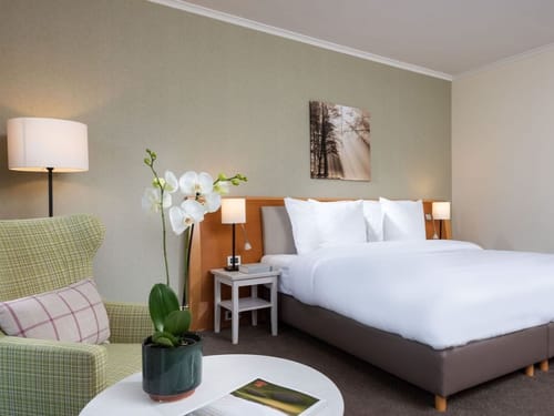 Doppelzimmer mit Sitzbereich und Stehlampe
