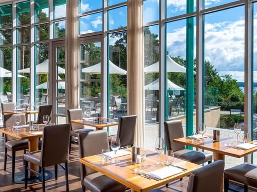 Restaurant mit eingedeckten Tischen und Blick auf den See