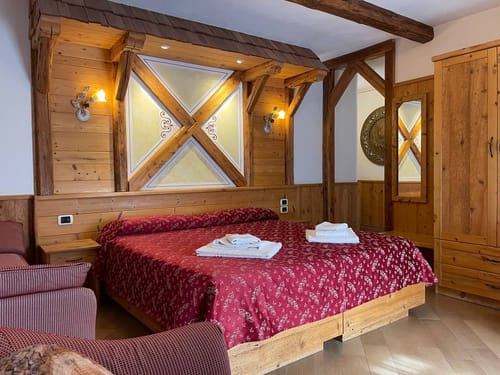 Gemütliches Hotelzimmer mit traditionellem Holzinterieur und Doppelbett