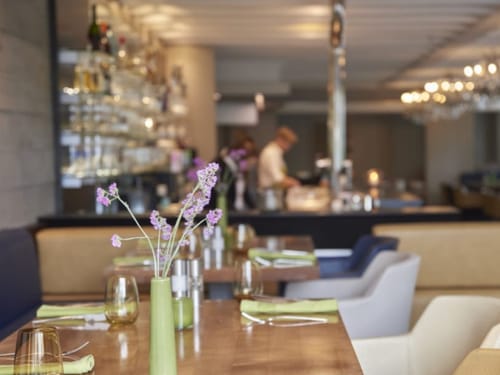 Modernes Restaurant mit stilvoll gedeckten Tischen und offener Küche