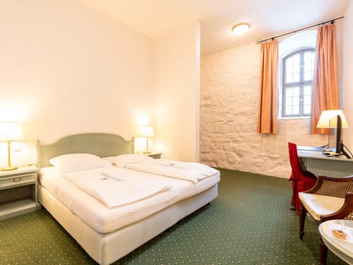 Stilvolles Doppelzimmer mit historischem Natursteinmauerwerk, antikem Flair und modernem Schlafkomfo
