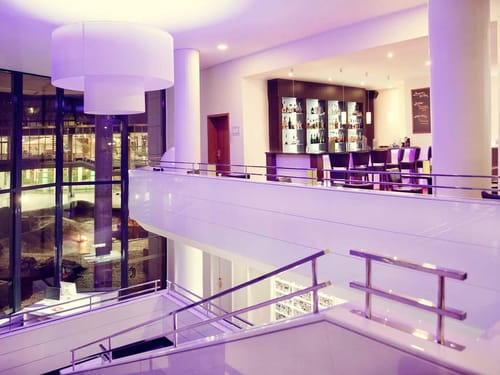 moderne Hotelhalle mit Treppenaufgang und Hotelbar