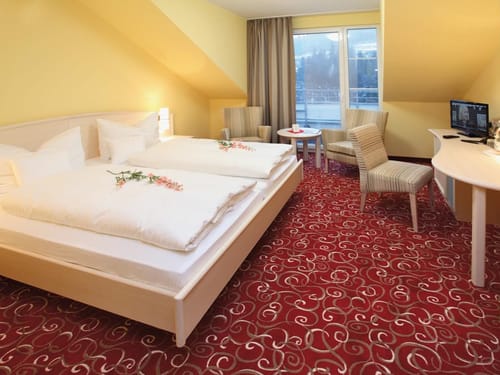 Doppelzimmer mit TV, Schreibtisch, Tisch und Stühlen
